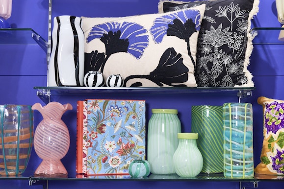 Brightly colours cushions, jars and vases displayed on shelves