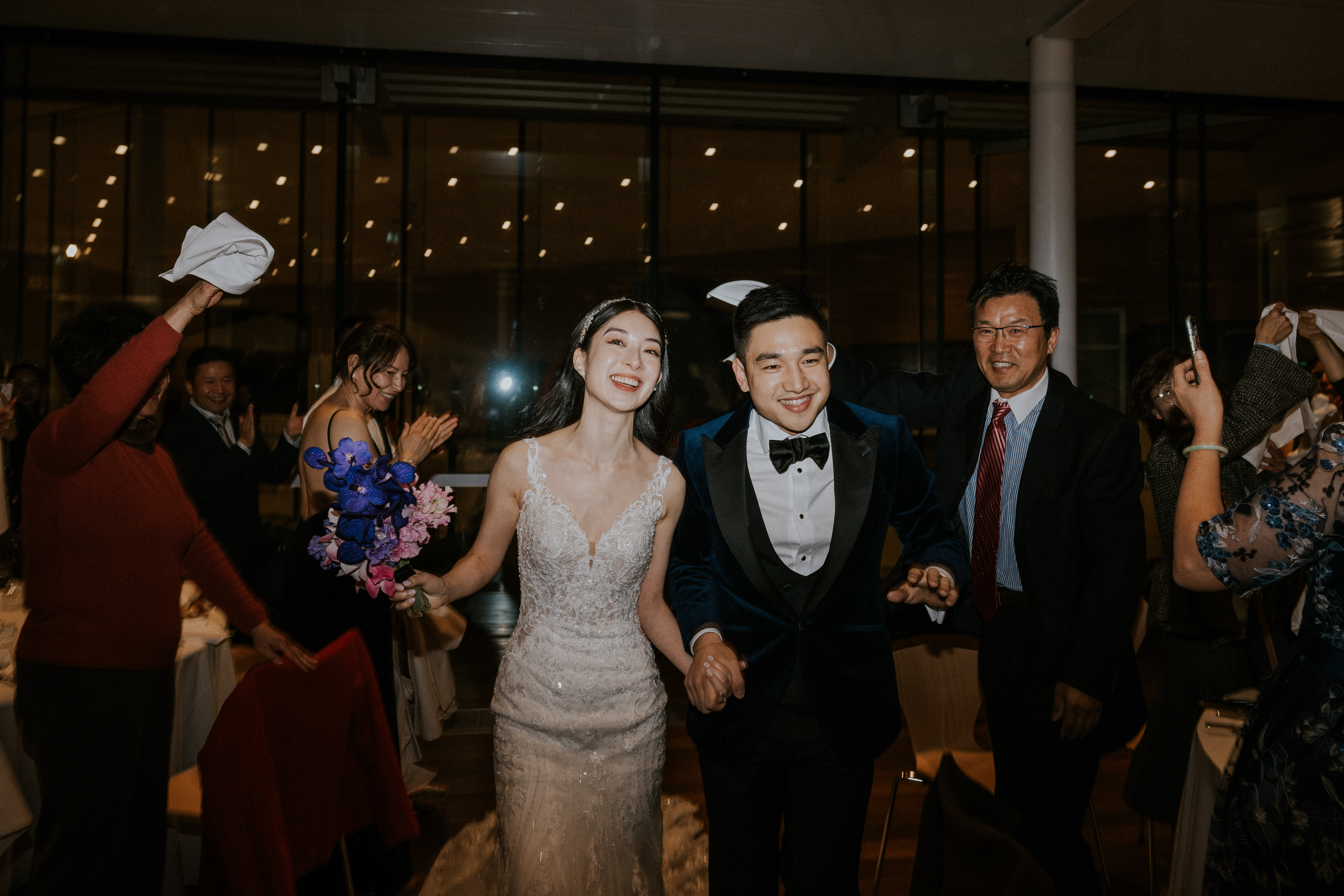 Bride and groom walk through their guests who cheer and raise their hands