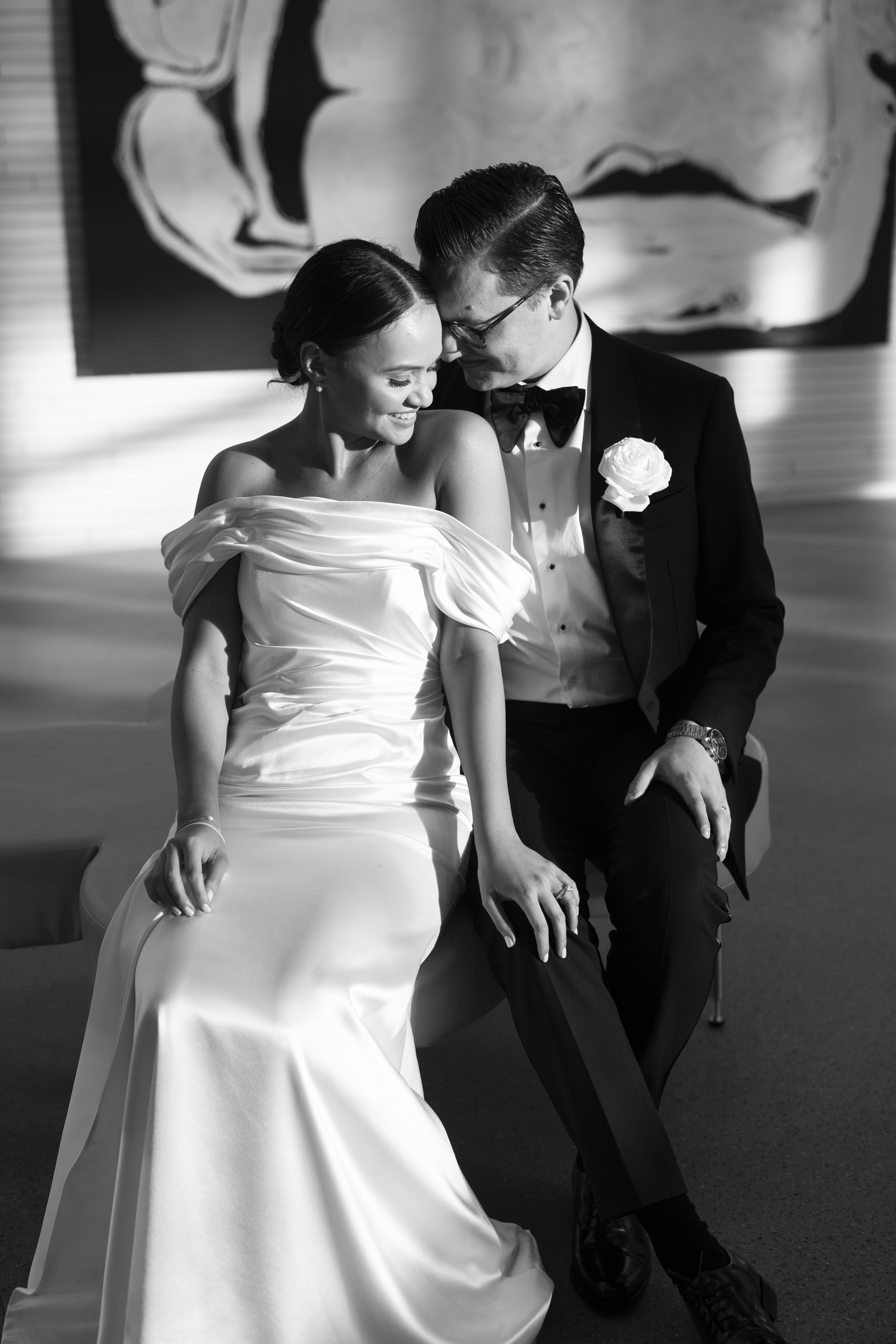 Newly wed man and woman sit lovingly next to each other