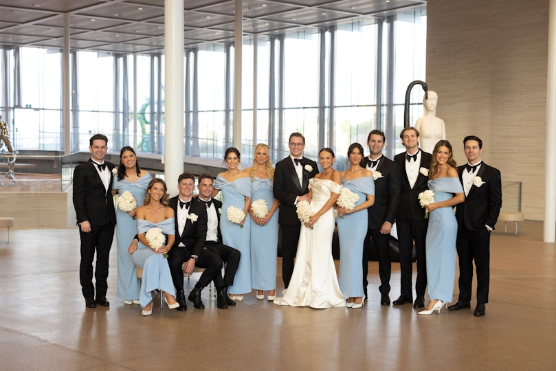 Newly wed couple pose with their bridesmaids and groomsmen