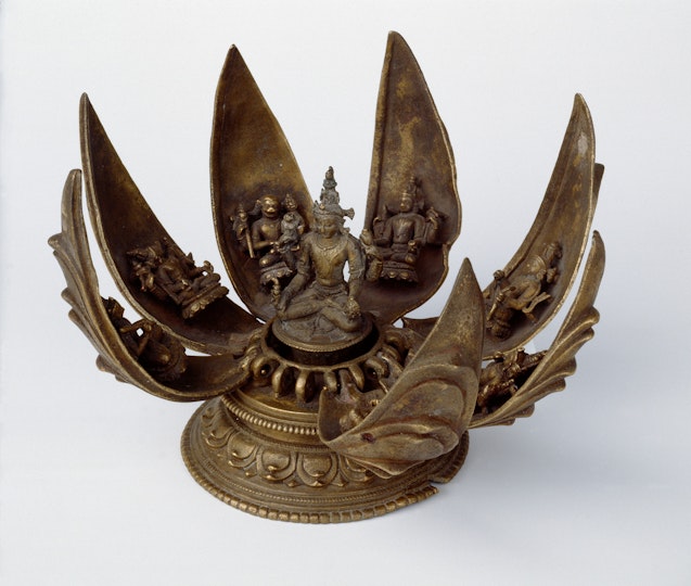Bronze sculpture of a central deity surrounded by smaller deities on unfolding lotus petals.