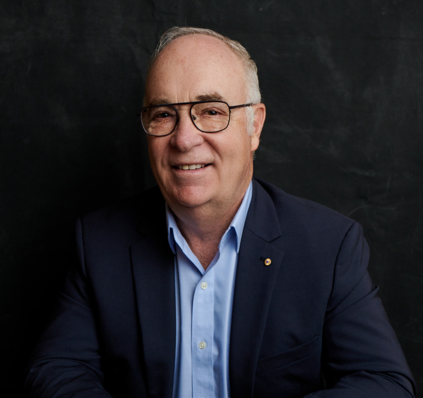 Headshot of a man, against a black background