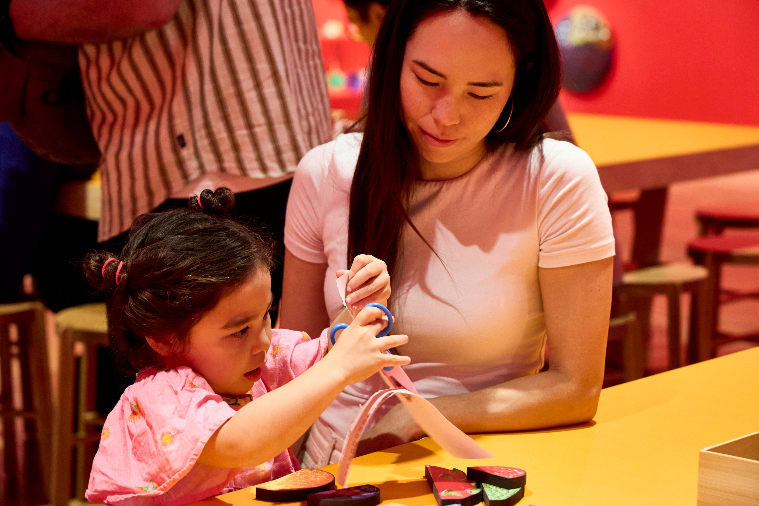 An adult and child doing a craft activity together