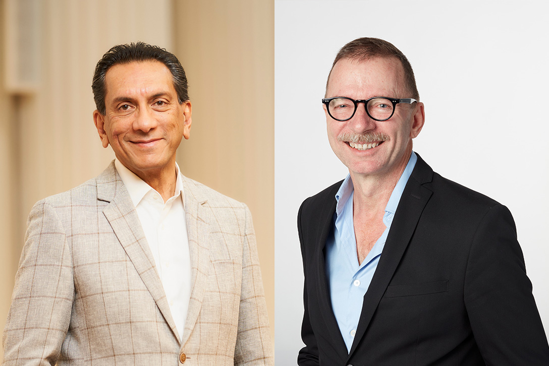 Two headshots side by side, of two men wearing suits, smiling at the camera.