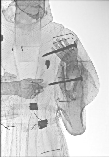 X-ray of a figurative sculpture revealing arms, hands and internal nails