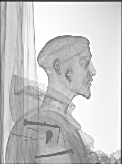 X-ray of a figurative sculpture revealing arms, hands and internal nails