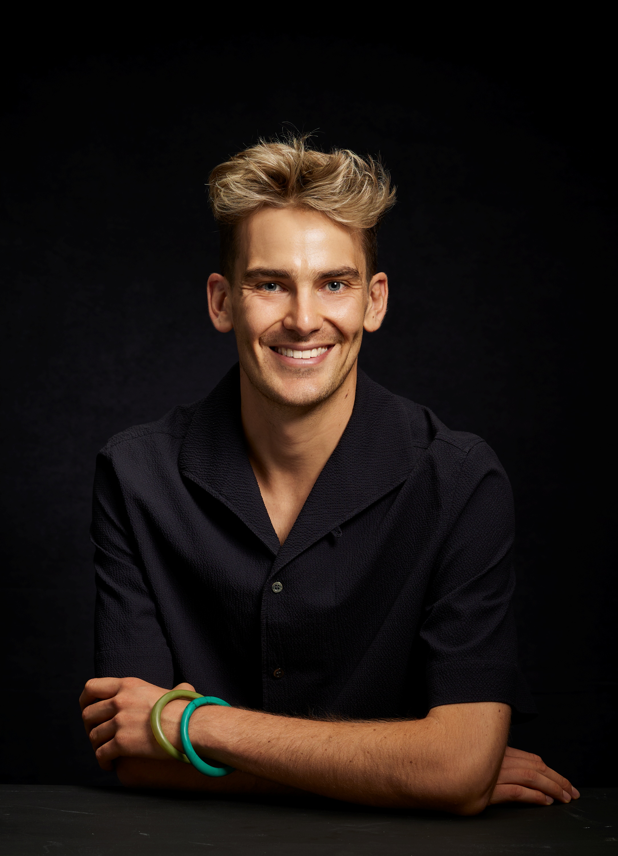 A man wearing a dark shirt smiling