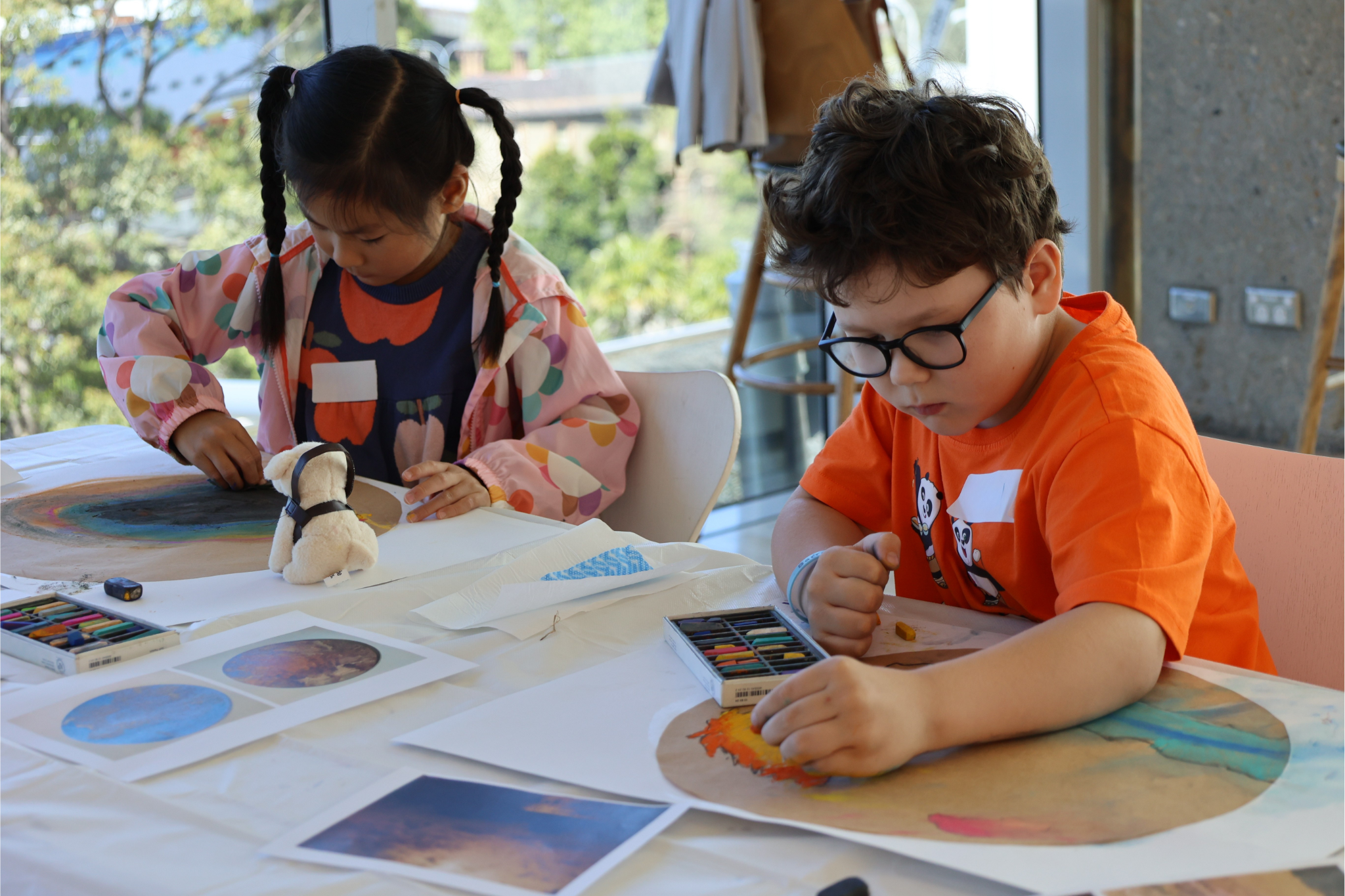 A girl and a boy drawing on paper