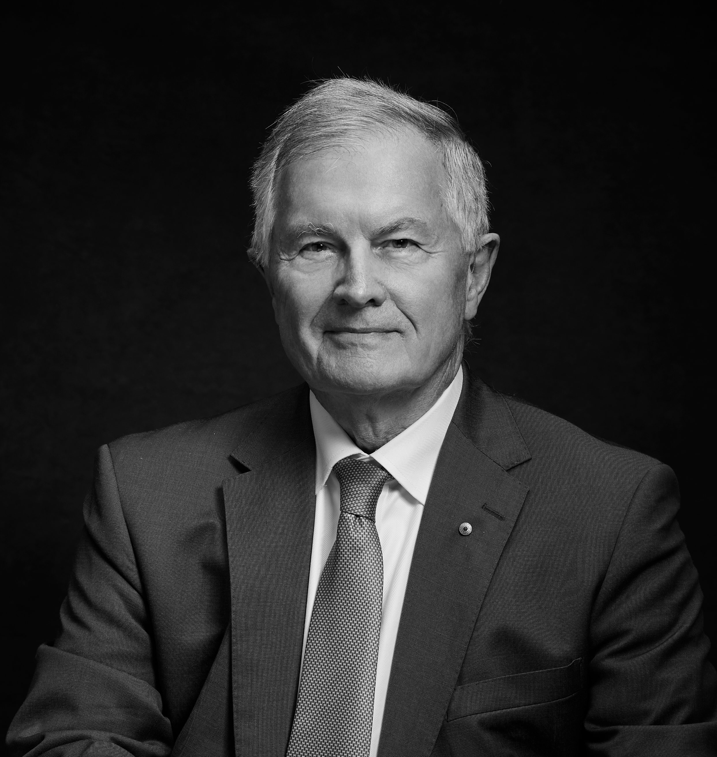 A man with short hair, wearing a suit.