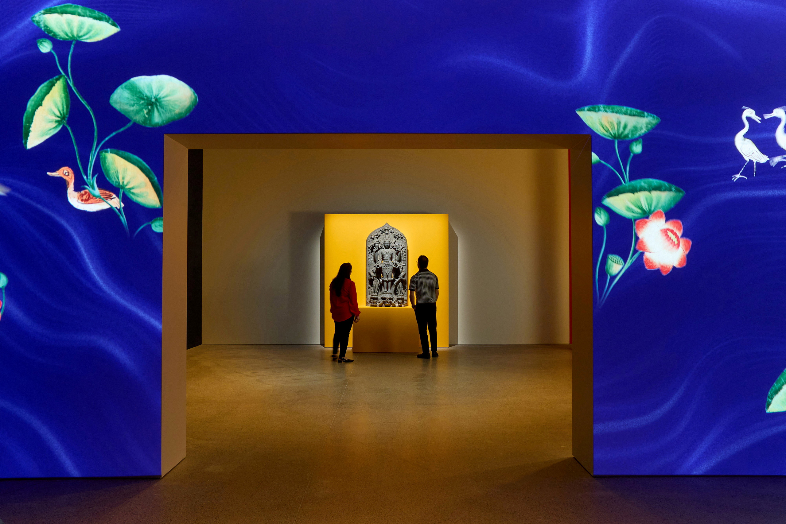 Visitors inside a gallery space looking at sculpture