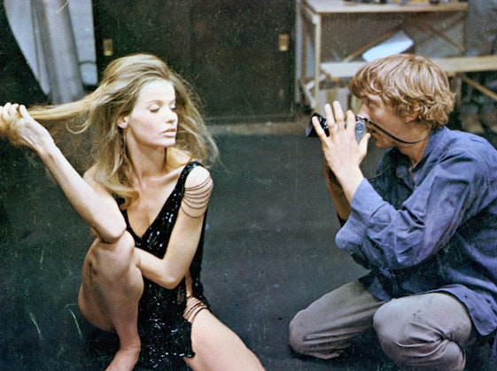 Blonde model posing for a photographer in the 1960s.