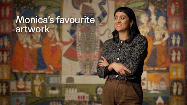 A woman stands with her arms folded, in front of a large artwork.