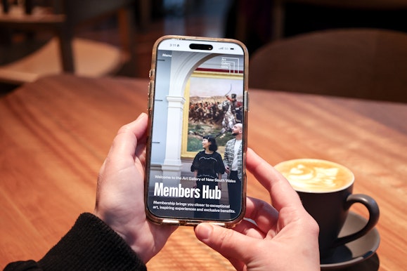Close-up of a person using a mobile phone in a café.