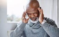 senior man suffering with a headache at home