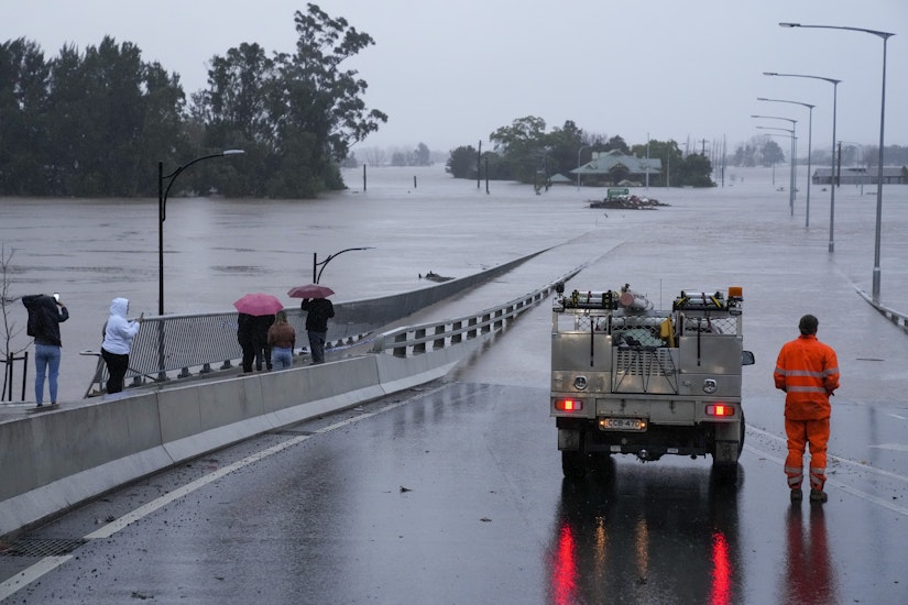 Un vehicul de urgență blochează accesul la Podul Windsor, inundat, de la periferia orașului Sydney, Australia
