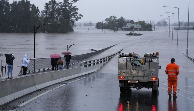 Un vehicul de urgență blochează accesul la Podul Windsor, inundat, de la periferia orașului Sydney, Australia