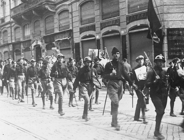 Un grup armat de fasciști italieni, mergând pe o stradă din Roma.