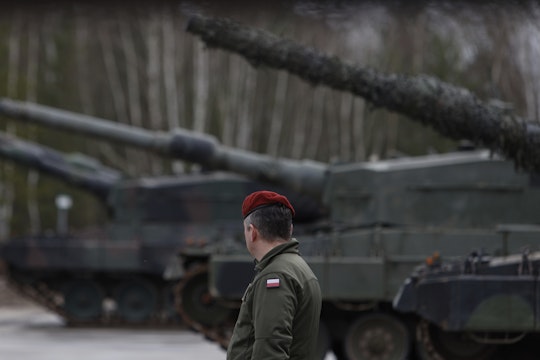 Un soldat polonez lângă mai multe tancuri Leopard 2
