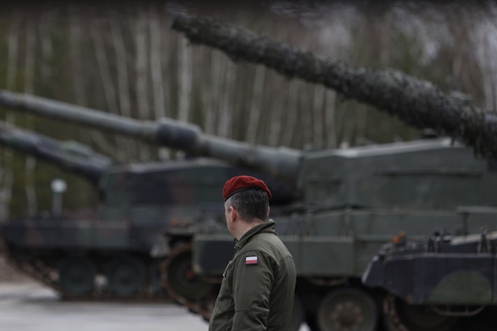 Un soldat polonez lângă mai multe tancuri Leopard 2