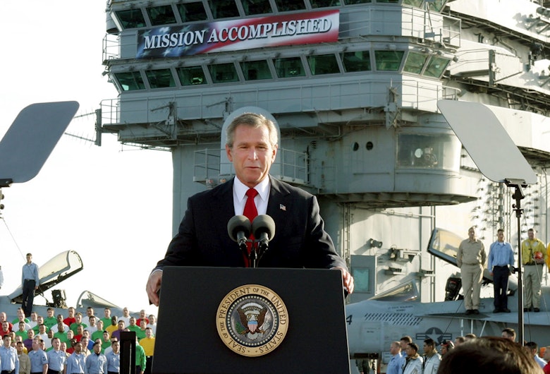 George W. Bush, la bordul portavionului USS Abraham Lincoln, anunțând că „operațiunile majore de luptă din Irak s-au încheiat”