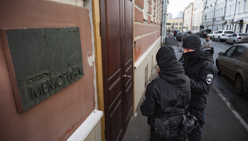 Doi ofițeri de poliție ruși stau în fața ușii biroului Memorial din Moscova, Rusia, marți, 21 martie 2023.