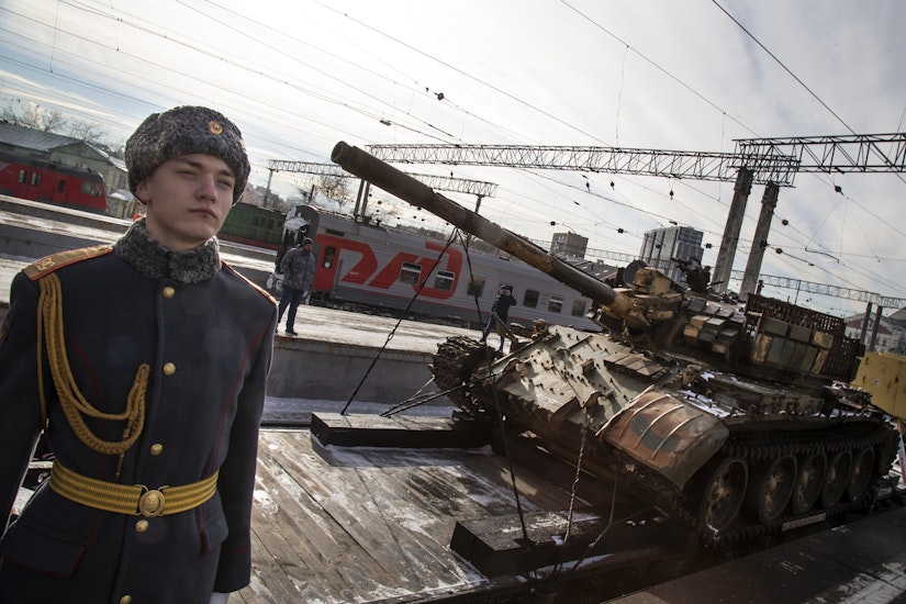 Un soldat stă lângă un tanc T-55 fabricat în Rusia