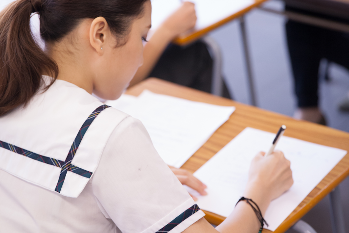 eleva scrie pe o foaie de examen