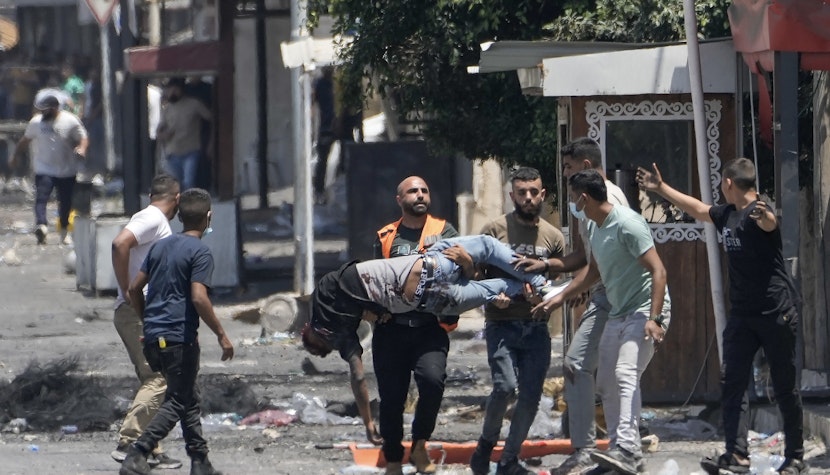 Palestinienii transportă un rănit în conflictele cu Israelul