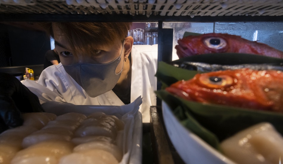 Un bucătar prepară pește în Hong Kong