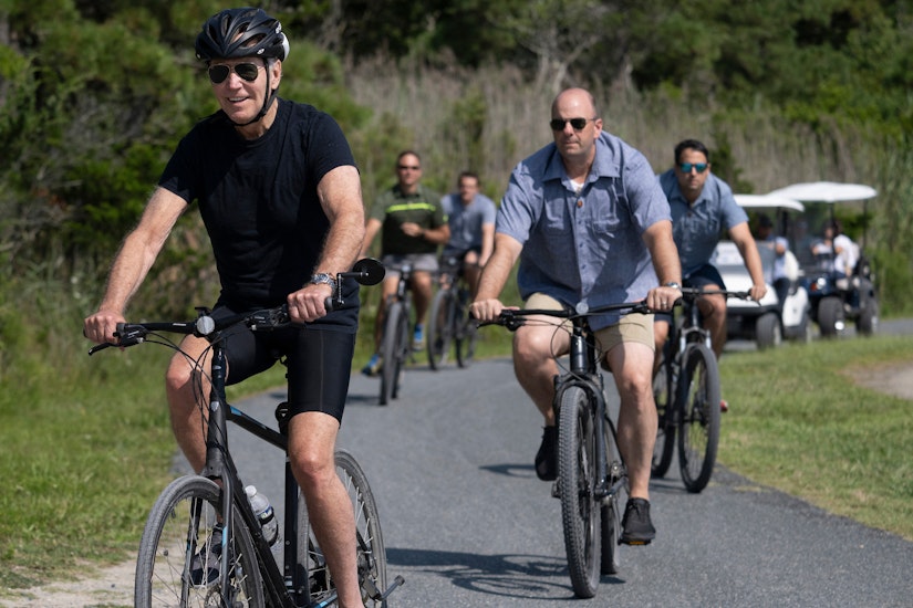 Joe Biden, pe bicicleta, imbracat in negru