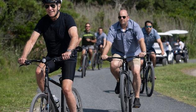 Joe Biden, pe bicicleta, imbracat in negru
