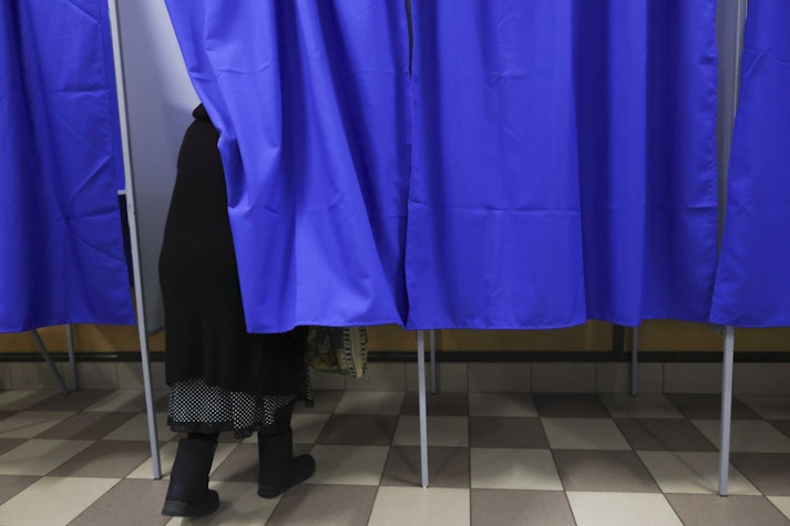 femeie intra in cabina de vot
