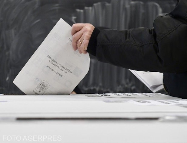 alegător introduce buletinul de vot în urnă