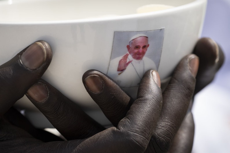maini care tin un bol cu chipul papei francisc