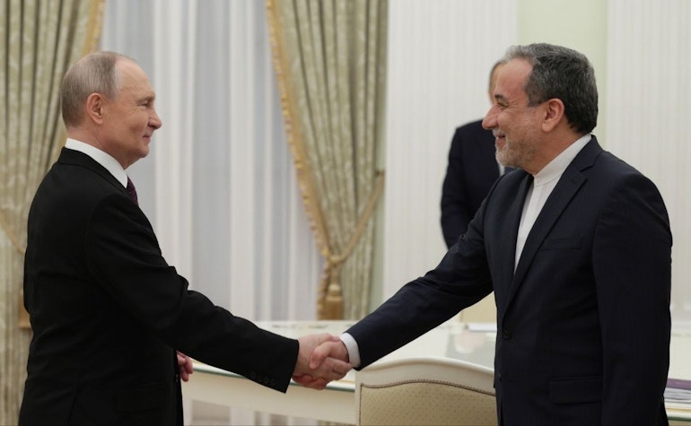 Vladimir Putin și Abbas Araghchi dând mâna unul cu altul