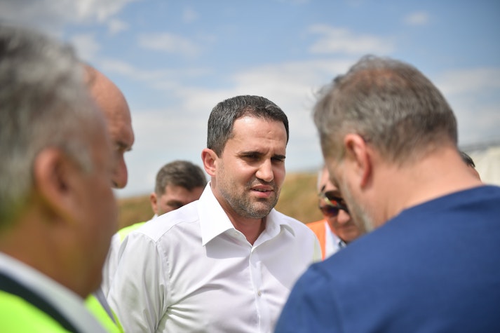 Ministrul Transporturilor și Infrastructurii, Ciprian Șerban, înconjurat de alte două persoane