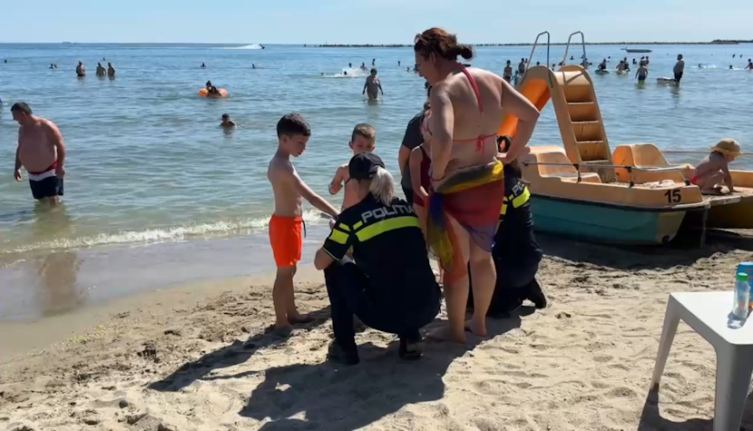 Ce faci când îți pierzi copilul pe plajă. Poliția sfătuiește părinții să sune rapid la 112 Agenți de poliție discută cu copiii și cu părinții pe plajă.
