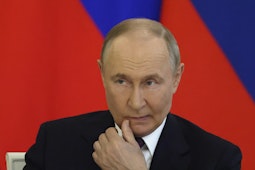 Vladimir Putin tinand o mana la coltul gurii