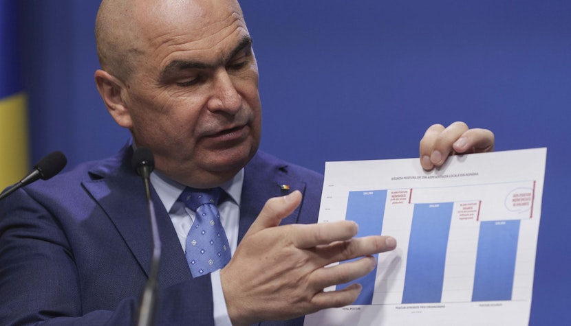 Premierul Ilie Bolojan ilie bolojan indică un grafic pe o foaie