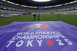 gazon cu un banner mov inscripționat cu logo-ul și textul World Athletics Championships Tokyo 25