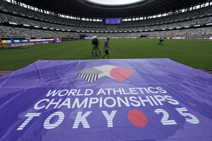 gazon cu un banner mov inscripționat cu logo-ul și textul World Athletics Championships Tokyo 25