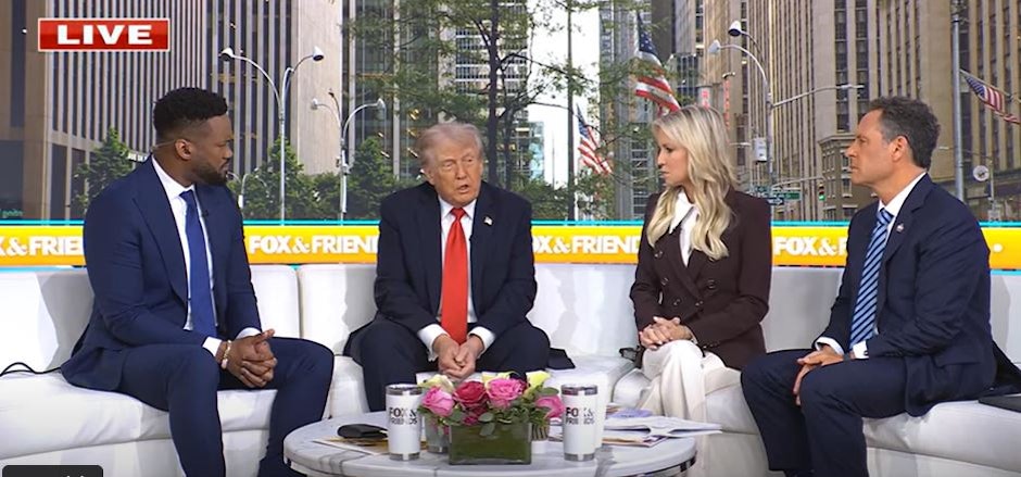 donald trump, pe o canapea albă, alături de alte trei persoane, într-un studio de televiziune