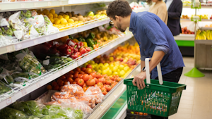 Bărbat cu un coș de cumpărături, la raionul de legume
