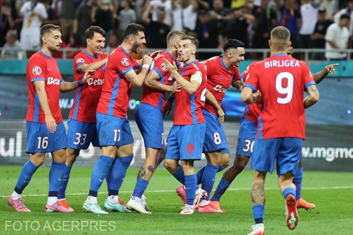 jucători fcsb în echipament roșu și albastru sărbătoresc un gol pe teren