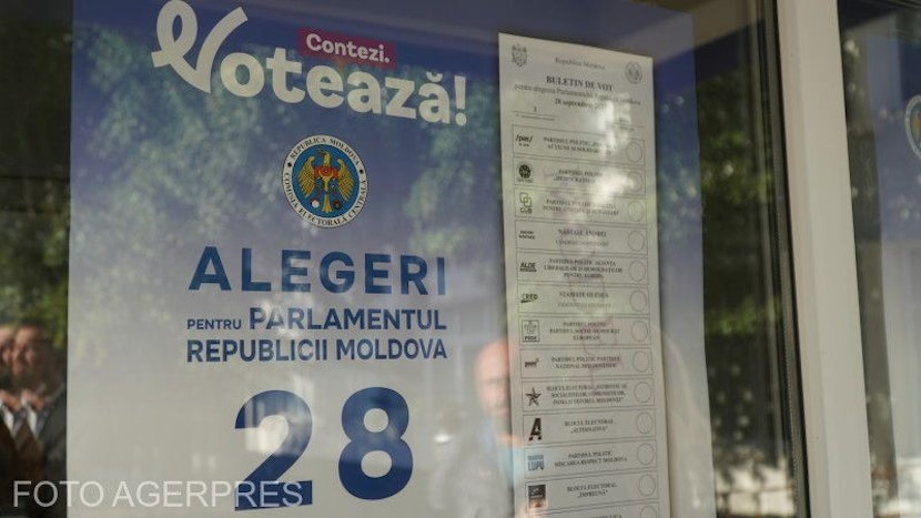 Afiș lipit pe geamul unei secții de votare, cu mesajul „Votează!”, sigla statului și textul „Alegeri pentru Parlamentul Republicii Moldova”