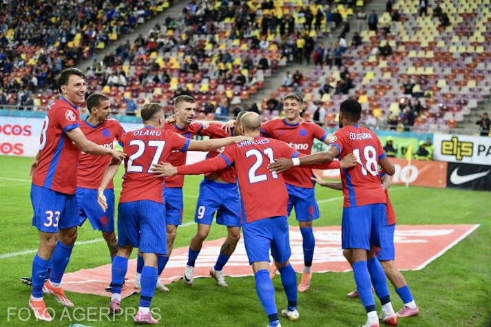 fotbaliști în echipament roșu și albastru sărbătoresc pe teren
