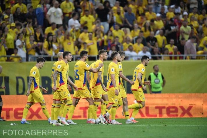 jucătorii echipei naționale de fotbal a româniei, în echipament galben, pe teren și cu suporteri pe fundal