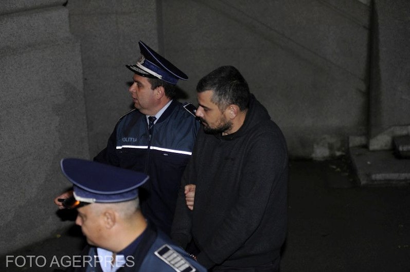 Costin Mincu (în negru), unul din patronii clubului Colectiv, escortat de doi polițiști