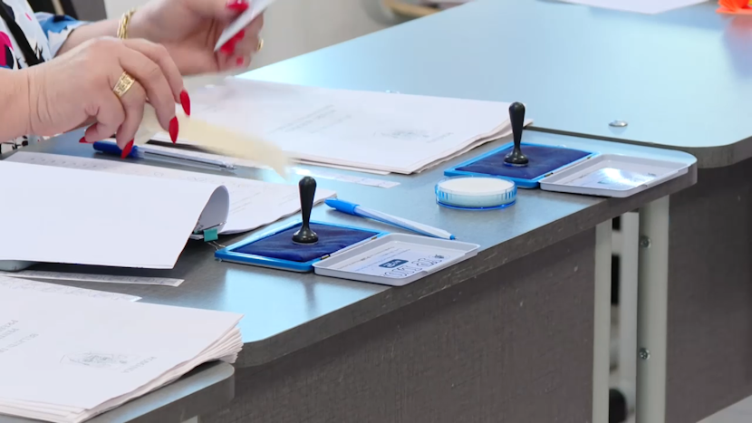 birou pe care sunt două ștampile de vot și listele de alegători
