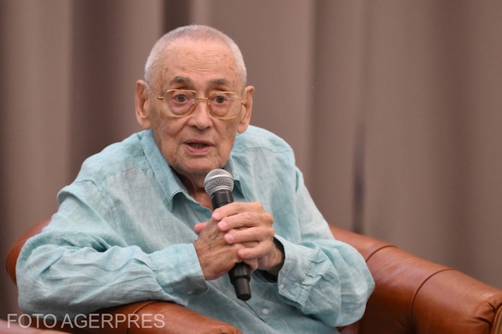 horia moculescu, într-o cămașă albastru deschis, vorbind la un microfon